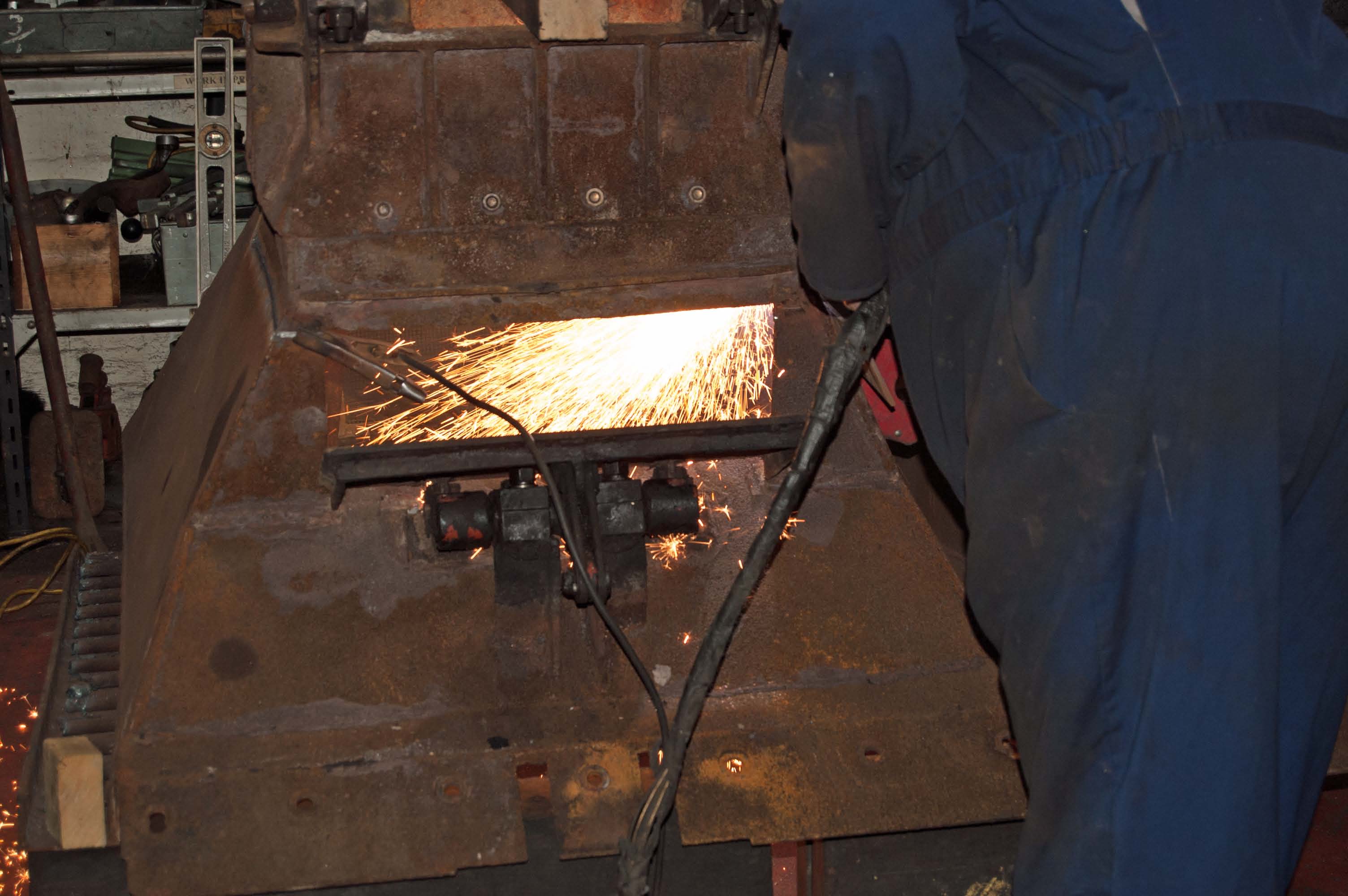 The plasma cutter is being used to remove damaged parts of the ashpans, so that they can be replaced or repaired.